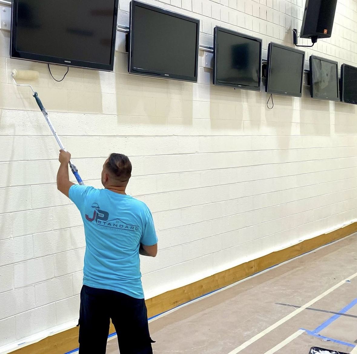 JP Standard painter rolling a block wall at New York University